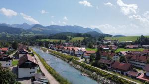 a view of a town with a river and houses at Berg Fux - Zwei Ferienhäuser mit je 5 und 6 Schlafzimmern mit eigener Dachterrasse - fantastischem Bergblick - Weber Gas Grill in Sonthofen +63 photos