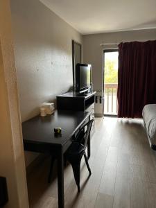 a room with a desk with a television and a bed at Park Inn in Colchester