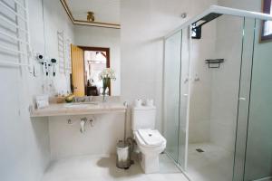 a bathroom with a shower and a toilet and a sink at Teatro Hotel Boutique in Ouro Preto