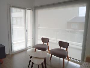 two chairs and a table in a room with a window at Malaika in Puerto Madryn