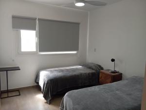 a bedroom with two beds and a window at Malaika in Puerto Madryn