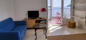 a living room with a blue couch and a television at Appartement Le Cap in Toulon