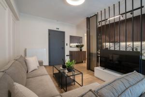 a living room with a couch and a television at The Fourth - Where Four Becomes Home in Larisa
