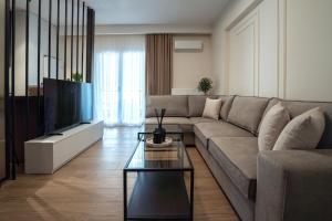 a living room with a couch and a flat screen tv at The Fourth - Where Four Becomes Home in Larisa +19 photos