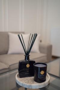 a table with a black vase and a candle on it at The Fourth - Where Four Becomes Home in Larisa