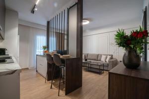 a kitchen and living room with a table and a couch at The Fourth - Where Four Becomes Home in Larisa