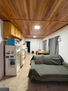 a room with a kitchen with a bed and a refrigerator at La Faustina in Chajarí