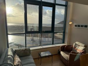 a living room with a large window with a view of the ocean at John's Luxury Seafront Apartment in Newcastle