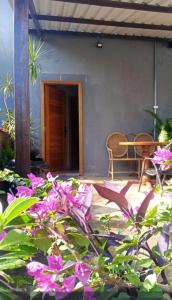 a patio with pink flowers and a table and chairs at Jardim Primavera in Palmas