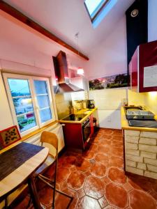 a kitchen with a table and a sink and a counter at Spa et Sauna Le Roosevelt in Château-Thierry