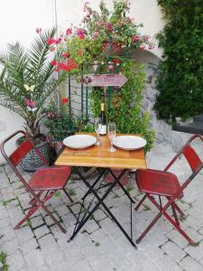 a table with two chairs and a bottle of wine at Spa et Sauna Le Roosevelt in Château-Thierry +19 photos