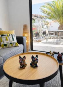 two figurines on a coffee table in a living room at Villa Sotavento Modern new apartment in Park Natural Adults Only in Playa Jandia