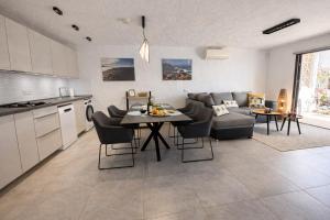 a kitchen and living room with a table and a couch at Villa Sotavento Modern new apartment in Park Natural Adults Only in Playa Jandia