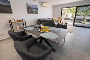 a living room with a table with a bowl of fruit at Villa Sotavento Modern new apartment in Park Natural Adults Only in Playa Jandia +21 photos