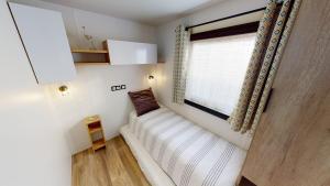a white couch in a room with a window at Vacances la Palmyre in Les Mathes
