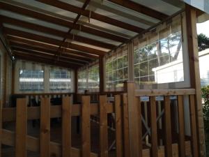 a wooden pavilion with windows and a wooden fence at Vacances la Palmyre in Les Mathes