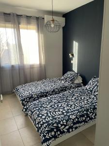 a bedroom with two beds and a window at appartement cosy in Nîmes