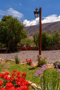a person sitting at a picnic table with flowers at Tala Huasi in Tilcara