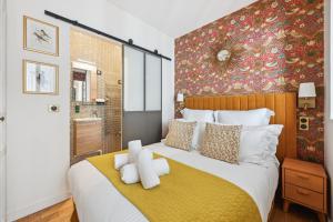 a bedroom with a large bed with a yellow blanket at La Maison Kléber - Luxury apartments, Eiffel Tower - Champs-Elysées in Paris