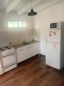 a kitchen with white appliances and a white refrigerator at Departamentos Ruca Lauquén in Necochea