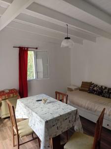a dining room with a table and a bed at Departamentos Ruca Lauquén in Necochea