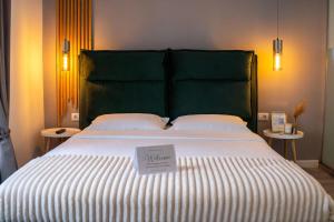 a large bed with a green headboard with a sign on it at Cozy Mountain Retreat in Transylvania Quiet Escape near Bran - Rai din Transilvania in Moieciu de Jos