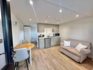 a kitchen and a living room with a couch and a table at Ballyaghran Stay in Portstewart +5 photos