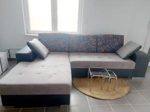 a couch and a stool in a living room at Lumière Luxembourg in Russange