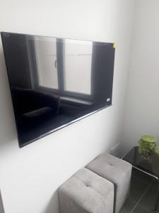 a mirror in a room with a chair and a stool at Lumière Luxembourg in Russange