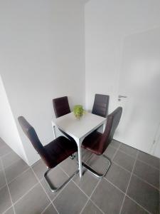 a white table with four chairs and a vase on it at Lumière Luxembourg in Russange