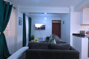 a living room with a couch and a kitchen at Lola Homes Thika in Thika