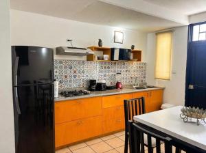 a kitchen with a black refrigerator and a table at Casa Natalia Welcome in La Paz