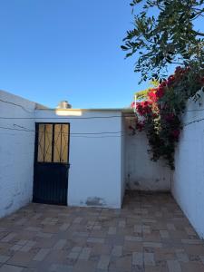 a white garage with a door on a wall at Casa Natalia Welcome in La Paz