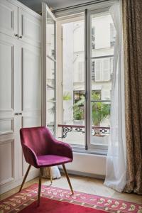 a purple chair sitting in front of a window at La Maison Kléber - Luxury apartments, Eiffel Tower - Champs-Elysées in Paris +70 photos