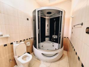 a bathroom with a toilet and a glass shower at Villa Media in Kigali
