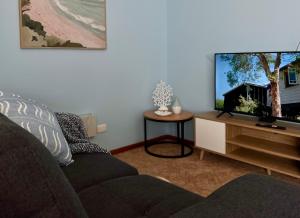 a living room with a couch and a flat screen tv at Howrah Apartment in Howrah