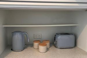 a shelf in a kitchen with four stools and a appliance at Howrah Apartment in Howrah