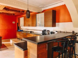a kitchen with orange walls and a black counter top at Villa Media in Kigali +43 photos
