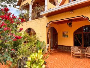 a house with a patio with chairs and flowers at Villa Media in Kigali