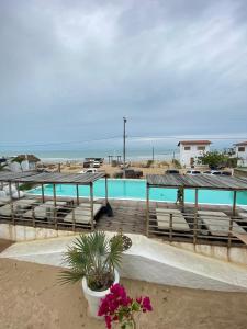 a deck with benches and a pool and the beach at Amagali Beach Club in Galinhos