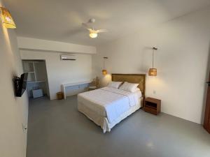a bedroom with a bed and a ceiling fan at Amagali Beach Club in Galinhos