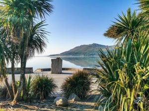 a beach with palm trees and a body of water at Church Lane Holiday Home, Warrenpoint in Warrenpoint