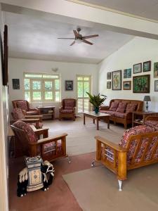 a living room with couches and a ceiling fan at Waterlily House in HUH +43 photos