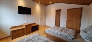 a bedroom with a bed and a tv on the wall at Lauermann's Gästehaus in Felixdorf