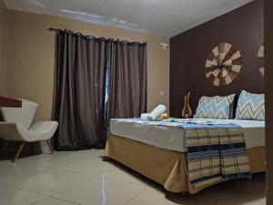 a bedroom with a bed and a chair in it at Pousada Aruana in Canoa Quebrada