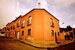 an orange building with a cross on top of it at Casa Rural El Lio in Ruidera