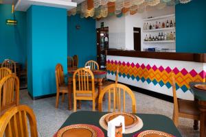 a restaurant with blue walls and wooden tables and chairs at Hotel Escala Siglo XXI in Mexico City