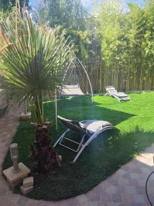 a garden with a hammock and a palm tree at Large Studio in a cozy house in Ormesson-sur-Marne