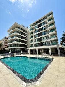 a swimming pool in front of a large building at SA Apartments! 150m to the Cleopatra Beach in Alanya