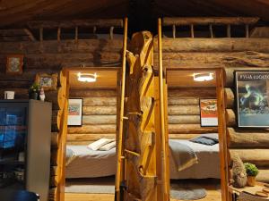 a bedroom with two bunk beds in a log cabin at Holiday Hopsukka in Luosto